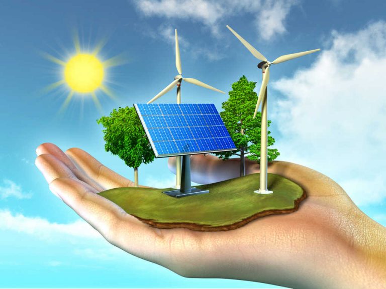 a hand holding a solar panel and wind turbines